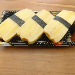 A slice of Japanese Omelette served on hand-pressed rice